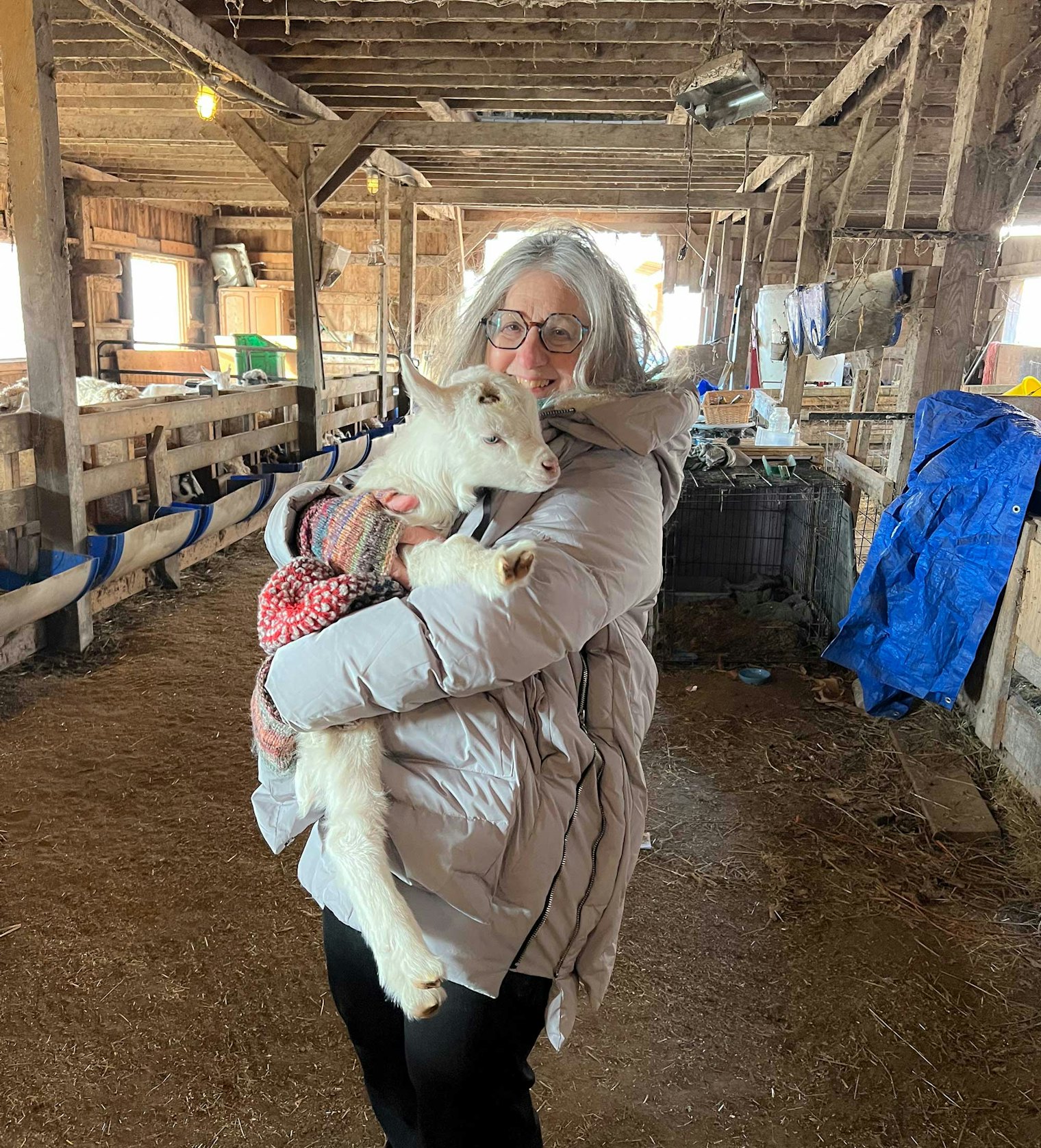 Photographer Gale Zucker holds a new kid in the barn.