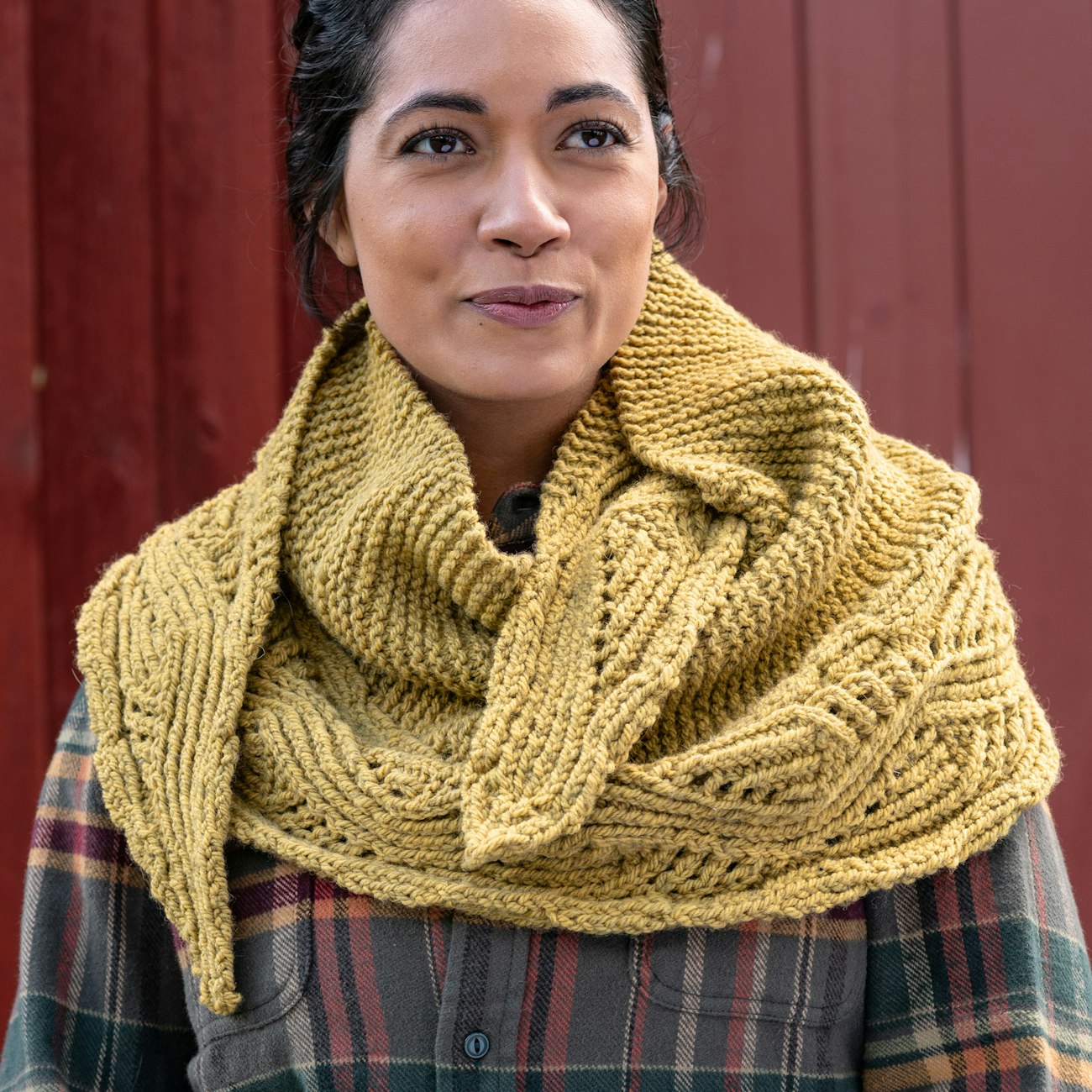 Woman in flannel shirt and gold handknitted shawl