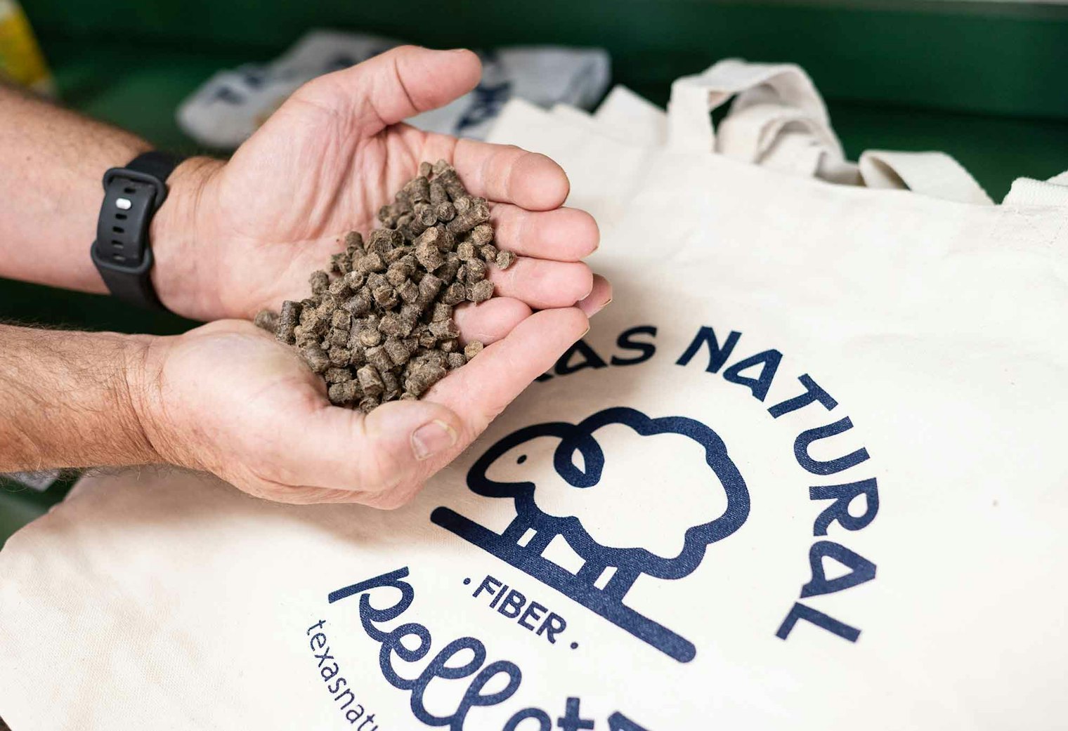 Don Thorp holds a handful of wool pellets made by The Rogue Skein from waste wool; the pellets are used to enhance soil for plants.