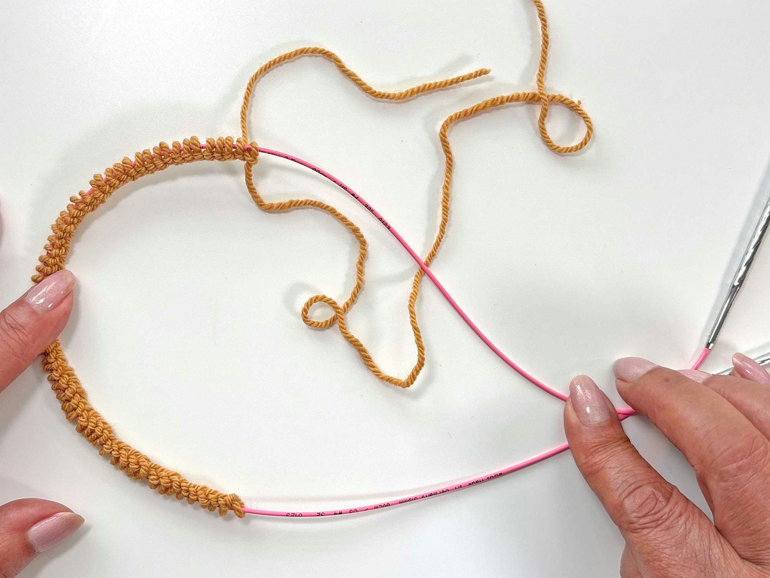 Move your stitches to the center of the cord between the needle tips.