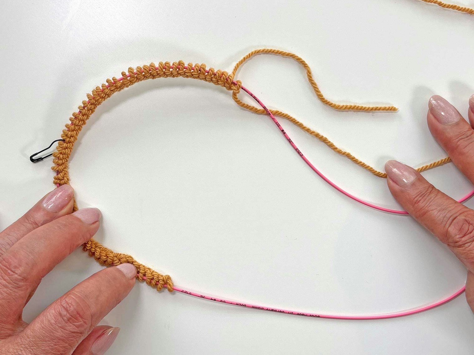 Place a removeable stitch marker on the needle cord in the middle of the stitches. In the example, there are 30 stitches on each side of the black stitch marker.