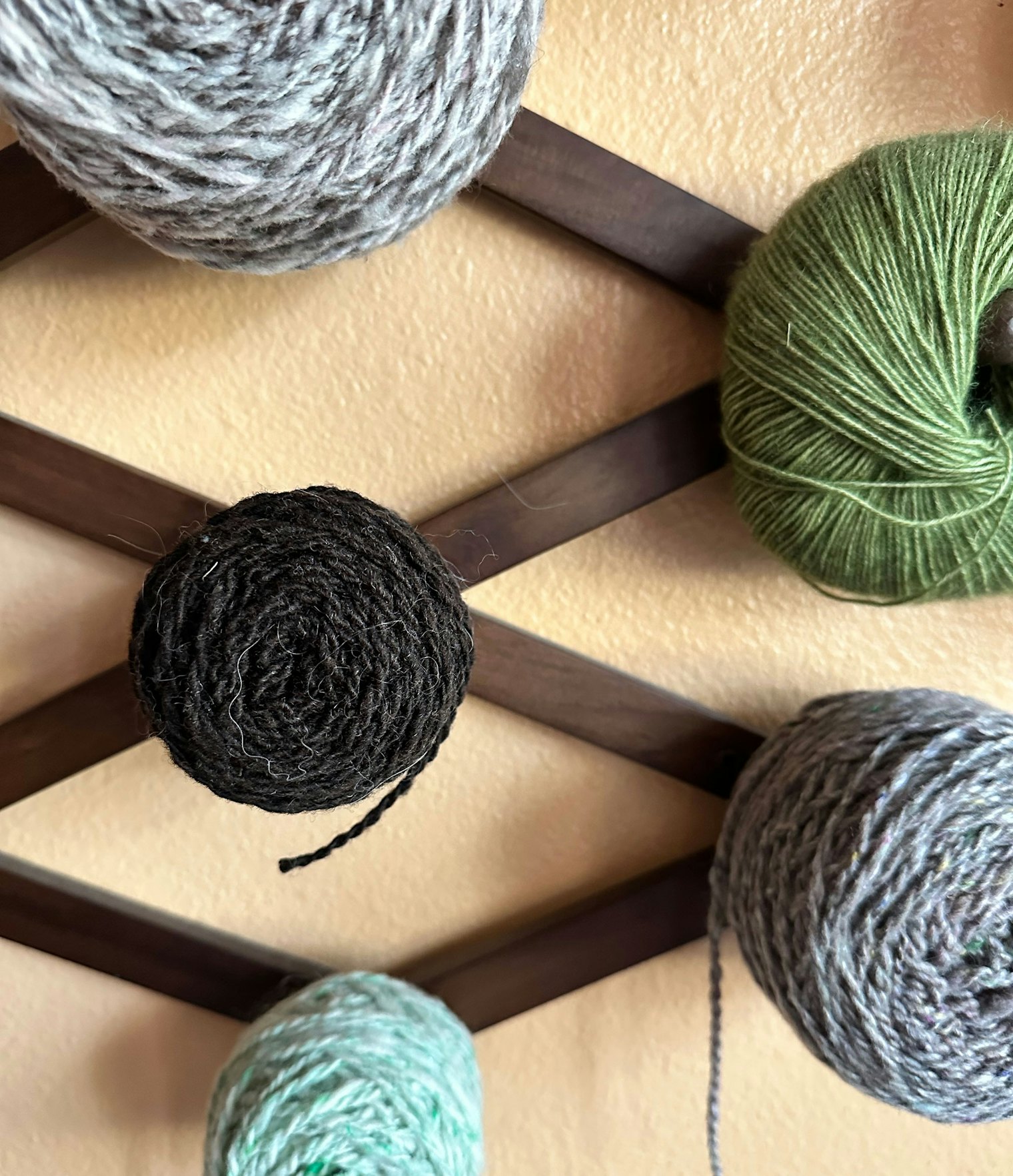 The dark skein on this wall of yarn is fleece from Pepper the sheep.