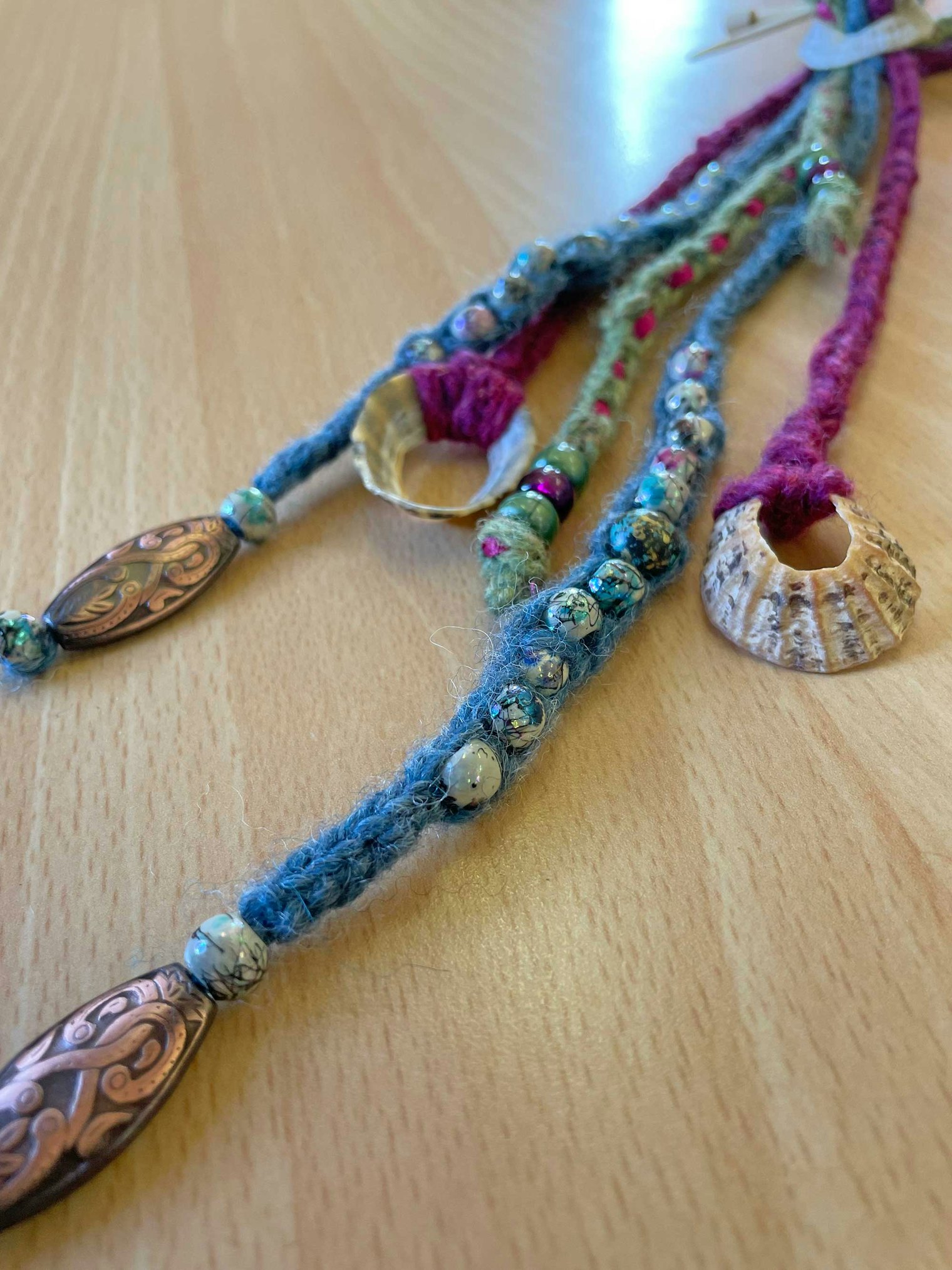 Helen taught Viking nalbinding and lucet cord making at Shetland Wool Week. Shown is the sample from her lucet cord class, showing how she worked beads and even shells into the braid. Photo by Cricket Cooper