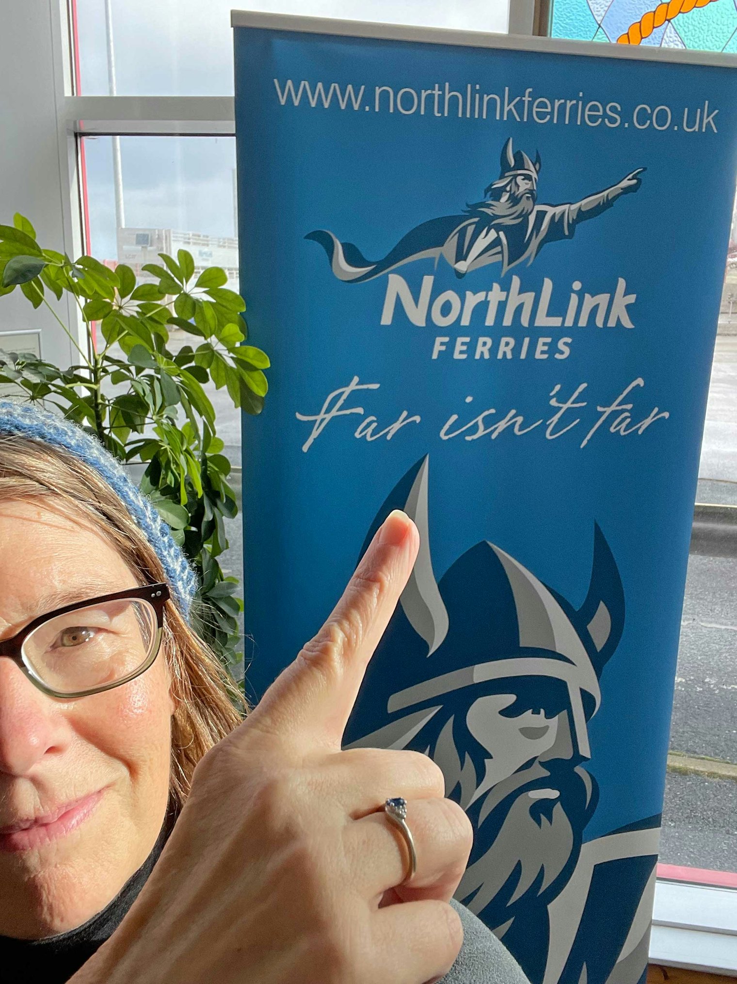 The author stands near a sign for the NorthLink Ferries, the ferry service connecting mainland Scotland and the Shetland Islands, which is a 216-mile overnight crossing. Photo by Cricket Cooper