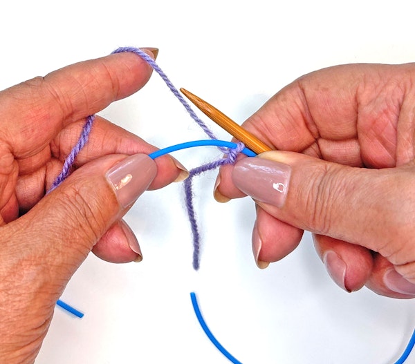 Hold the needle and cord in your right hand.