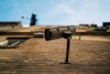 Looking up at security camera mounted on a brick wall with blue sky in the background.