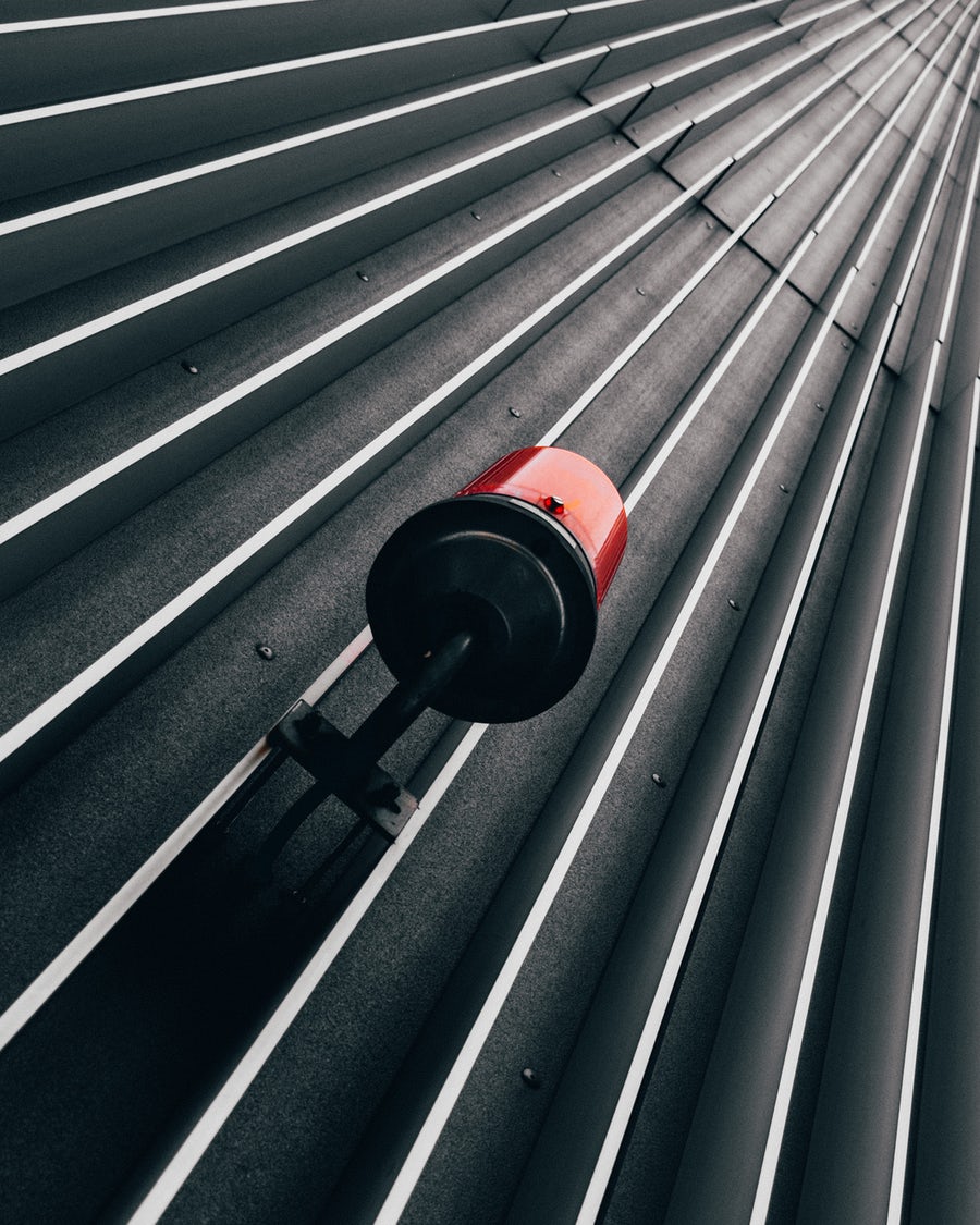 Red emergency alarm light mounted on the outside of a wall.