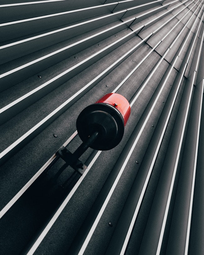 Red emergency alarm light mounted on the outside of a wall.