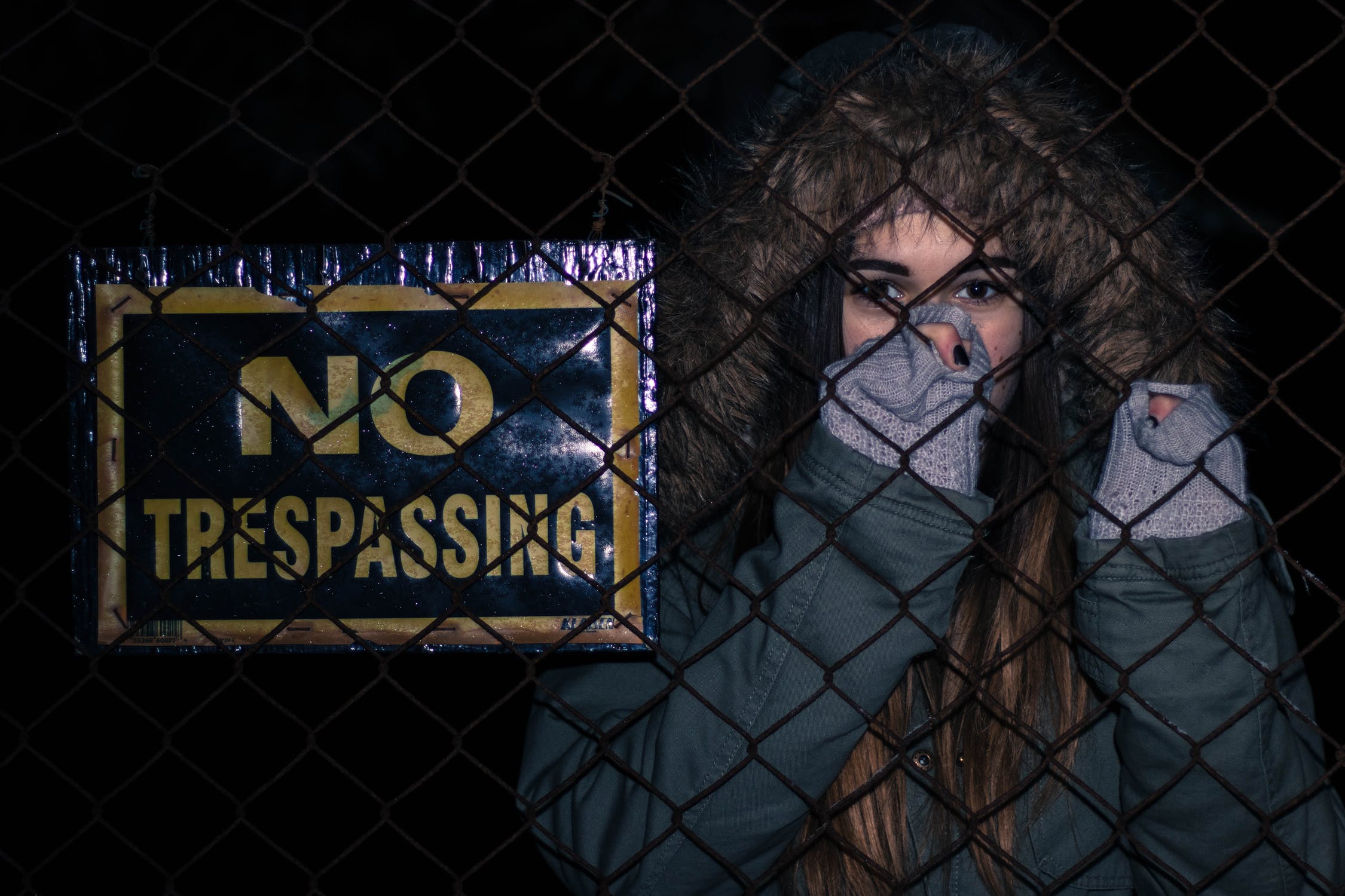 Woman Trespassing Behind Fence With No Trespassing Sign On It