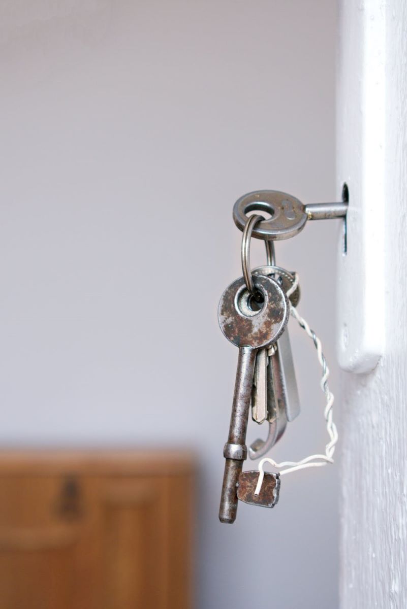 A set of old keys hanging from a door lock.