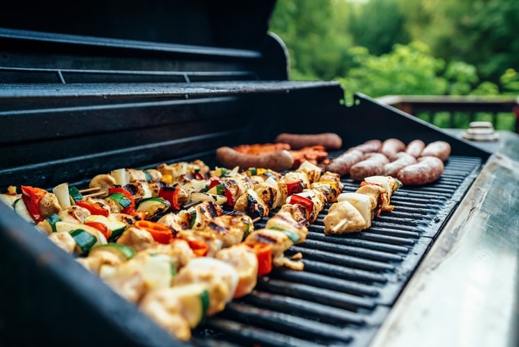 Various meats cooking on a grill or bbq.