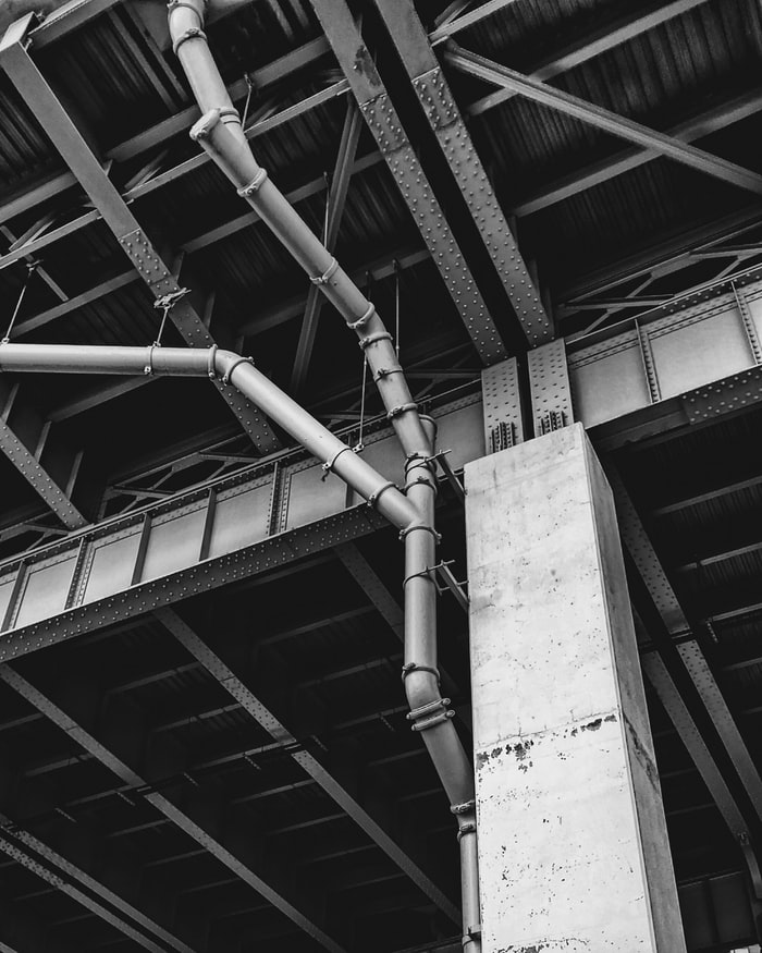 Pipes pumping out Carbon Monoxide in a warehouse of metal and cement