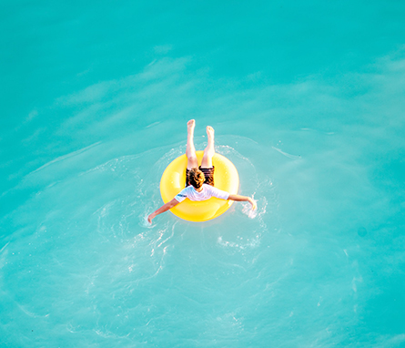 child floating in yellow tube in the pool