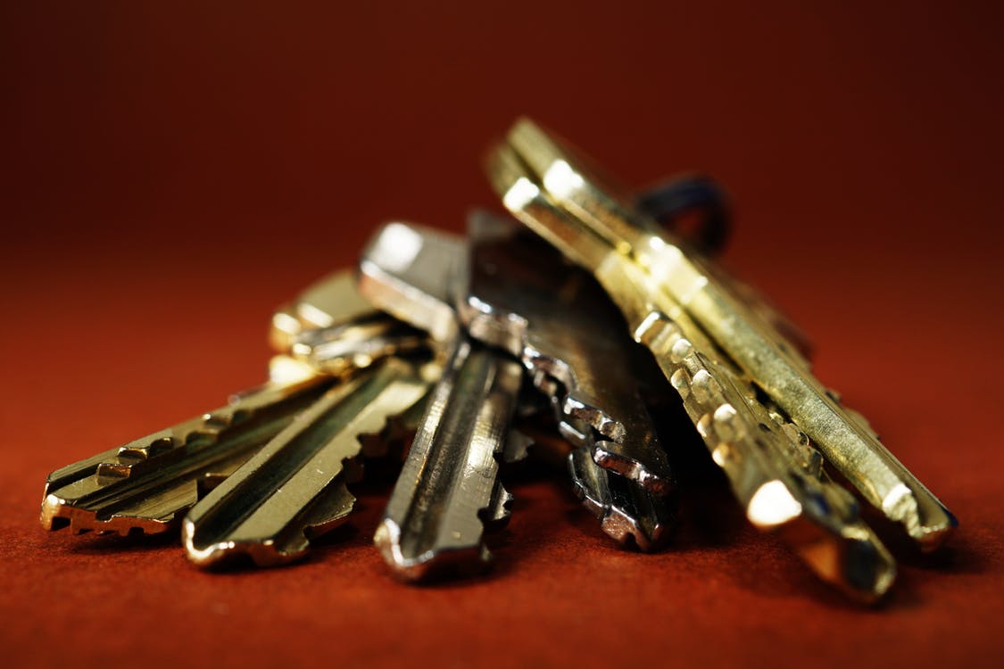 A ring of keys lying on their side with a red background behind it. 