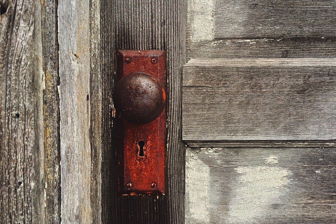 Old Door With Peeling Paint and old fashioned keyhole and door knob