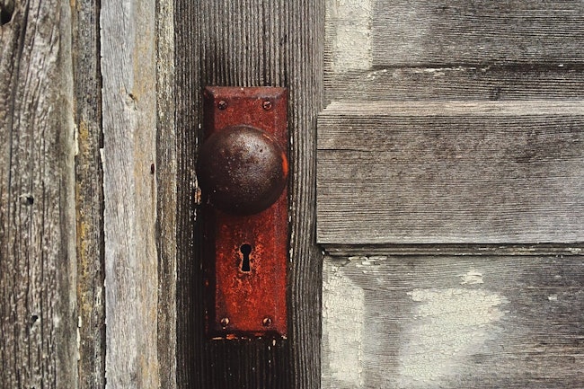Old Door With Peeling Paint and old fashioned keyhole and door knob