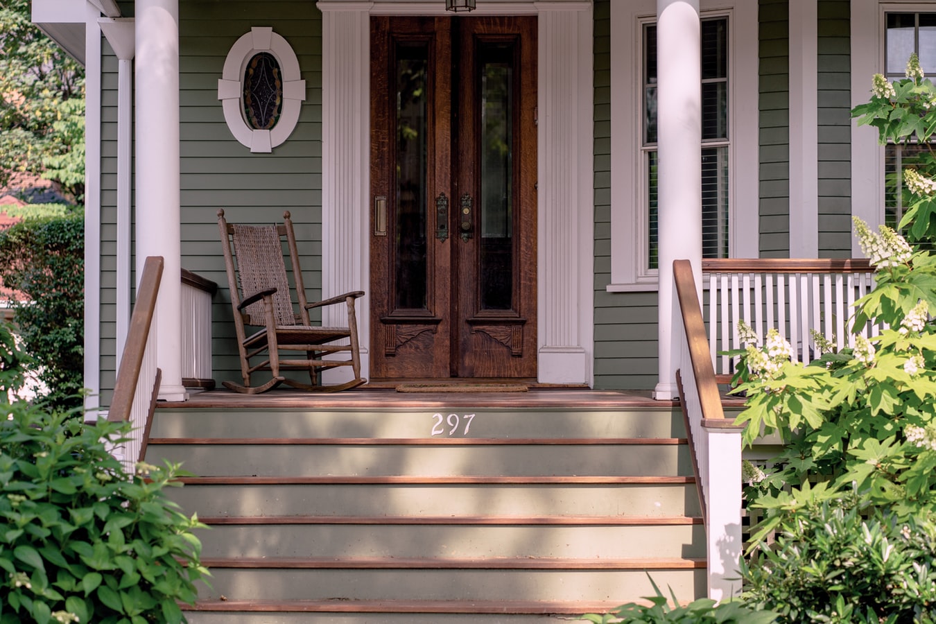 Rocking Chair on Porch, Wood Double Doors, and several stairs.