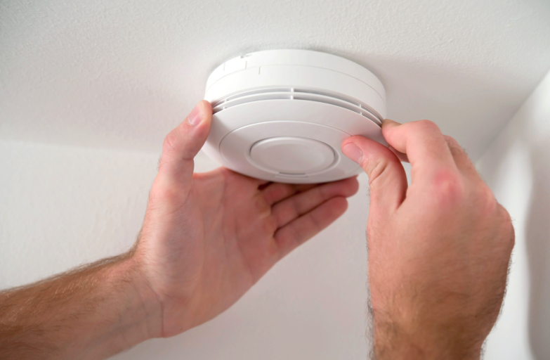 Carbon Monoxide Alarm Being Installed by two hands