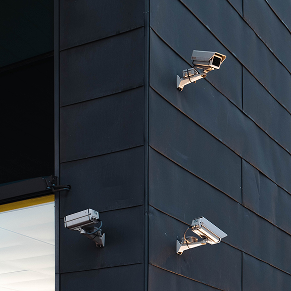 Three 1080p Security Cameras mounted onto the edge of a black walled building.