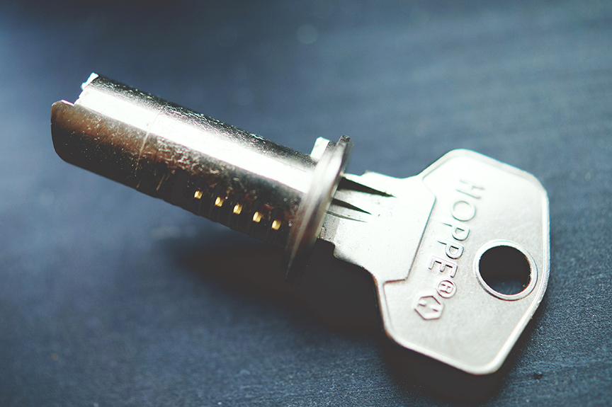 The cylindrical deadbolt lock chamber with a key inserted, lying on a table.