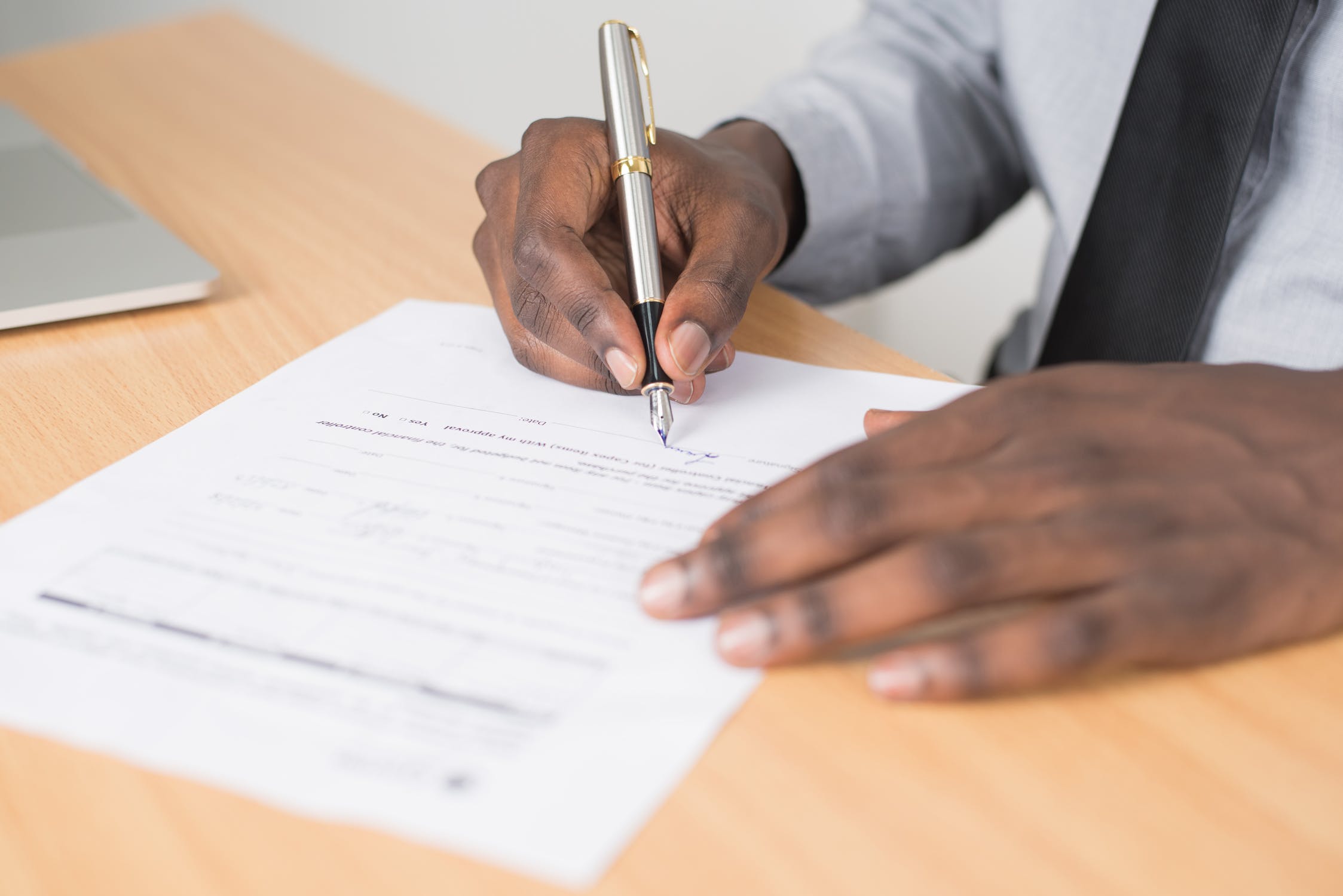 close up of person filling out an alarm permit with a pen.