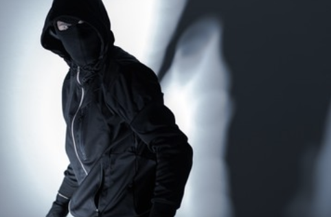 Stalker dressed all in black with face obscured by a balaclava and hood