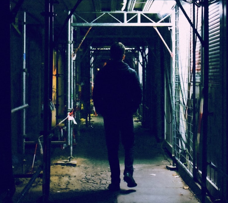 Stalker Walking Through a Run Down Hallway in the City