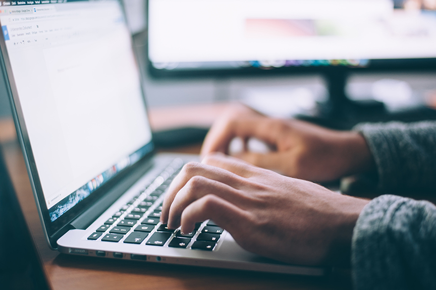 Close up of business employee typing on his laptop.