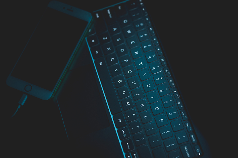 Laptop and Cell Phone in Dark Lighting Used for Hacking Cellular Security Cameras
