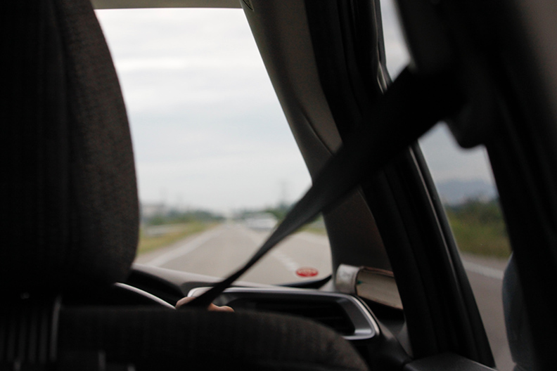 Over the shoulder shot of person driving on the highway.