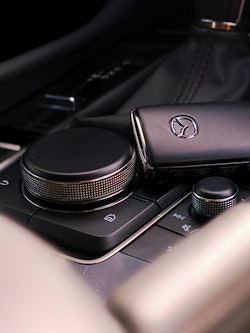 close up of a Key fob lying on top the center console in a car.