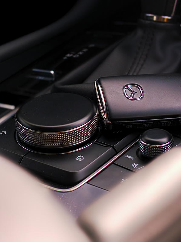 close up of a Key fob lying on top the center console in a car.