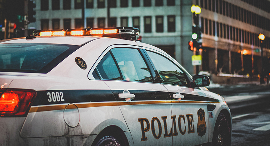 Police Car Responding to a False Alarm with lights on in the city.