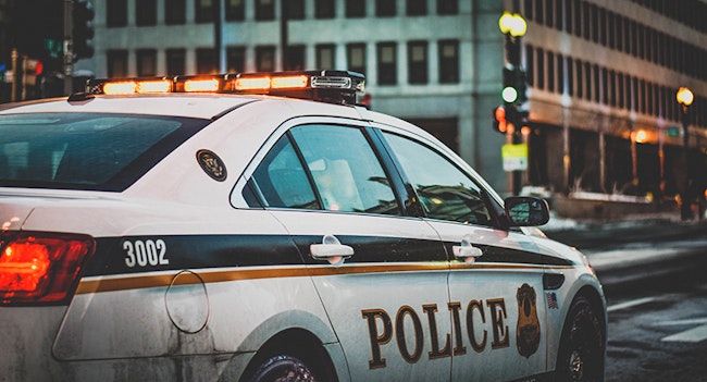 Police Car Responding to a False Alarm with lights on in the city.