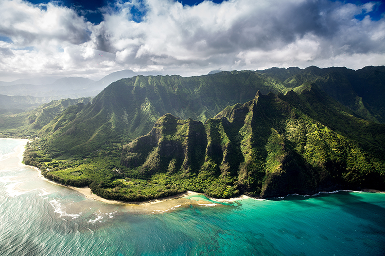Looking down at the green mountains and clear water of Kauai.