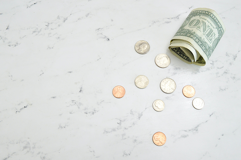 a few dollars and coins on a table demonstrating how affordable Cove's monthly monitoring fee is.