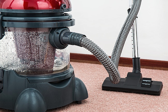 Vacuum cleaner sucking up air pollutants from the carpet.