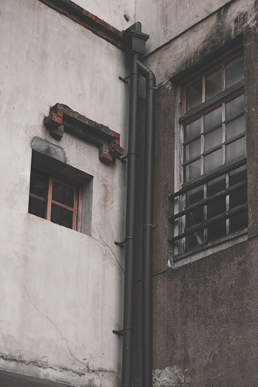 Pipes running up the corner of an old building.