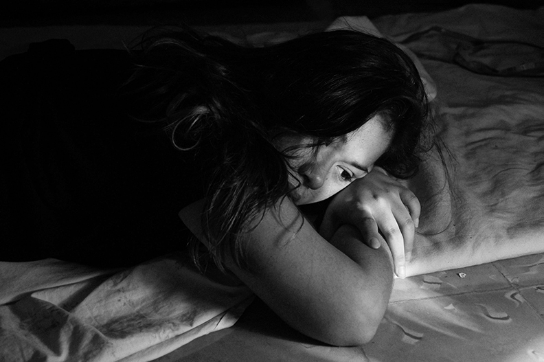 Women suffering from domestic abuse, lying on the ground.