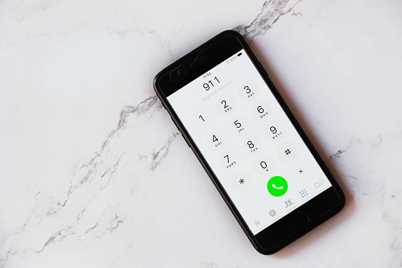 Phone lying on marble with 911 typed in.
