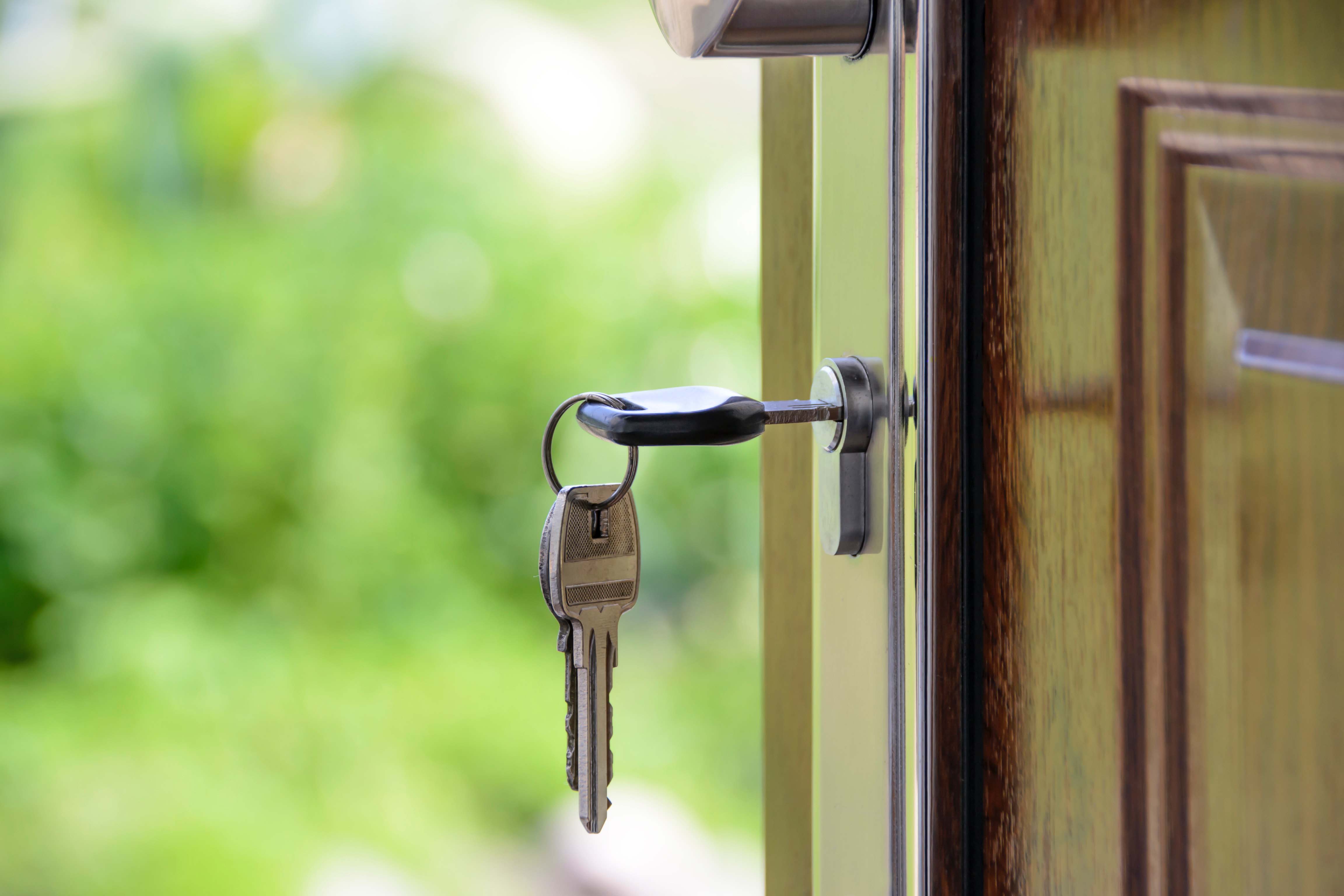 Key in keyhole hanging from an open door.