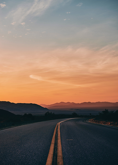 A Road running through Barstow. Desert mountains can be seen in the distance.
