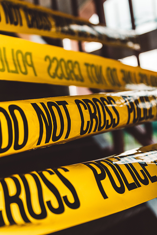 Several pieces of yellow crime scene tape reading, "Police line. Do not cross."