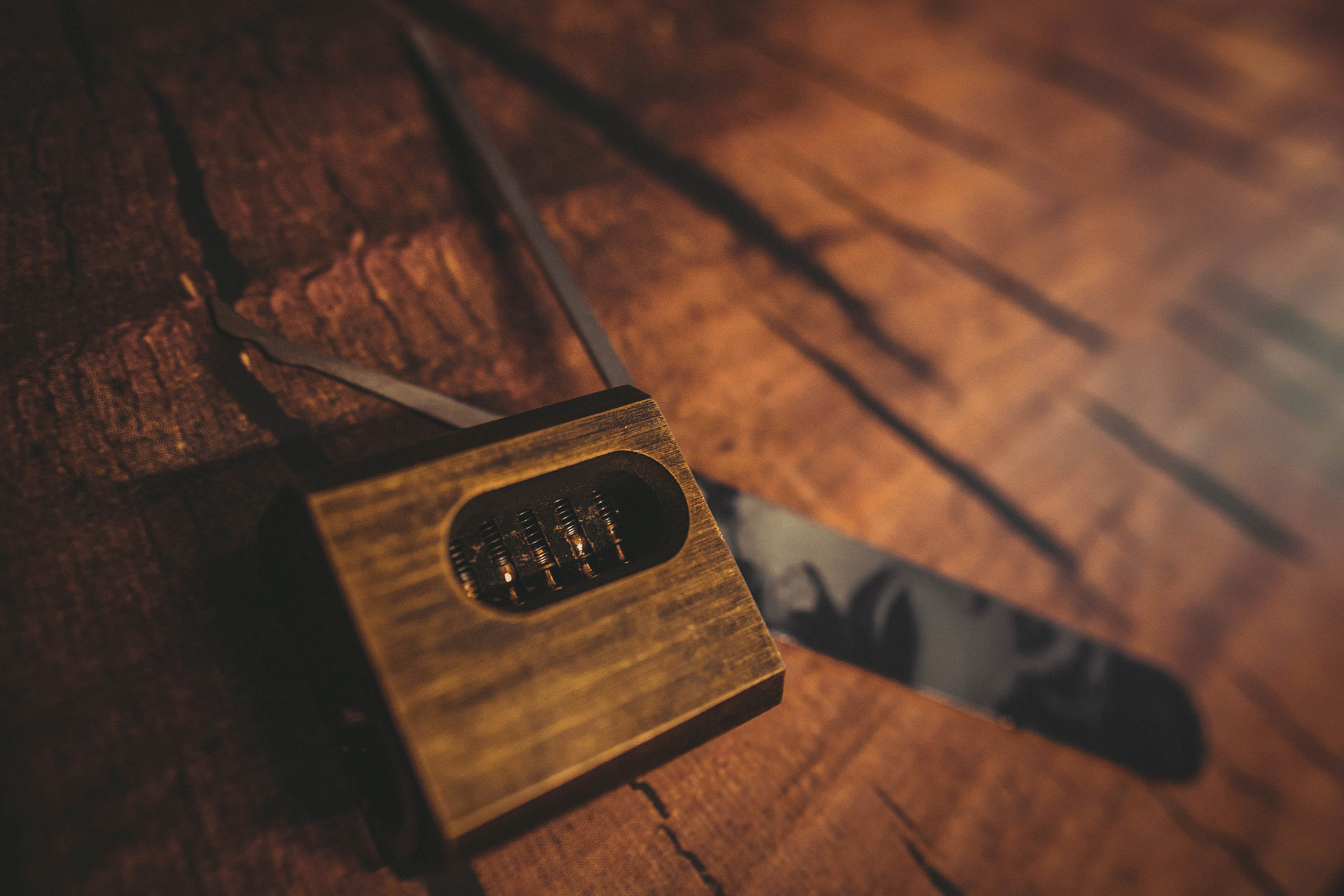 A lock and lockpick on top of a wooden surface