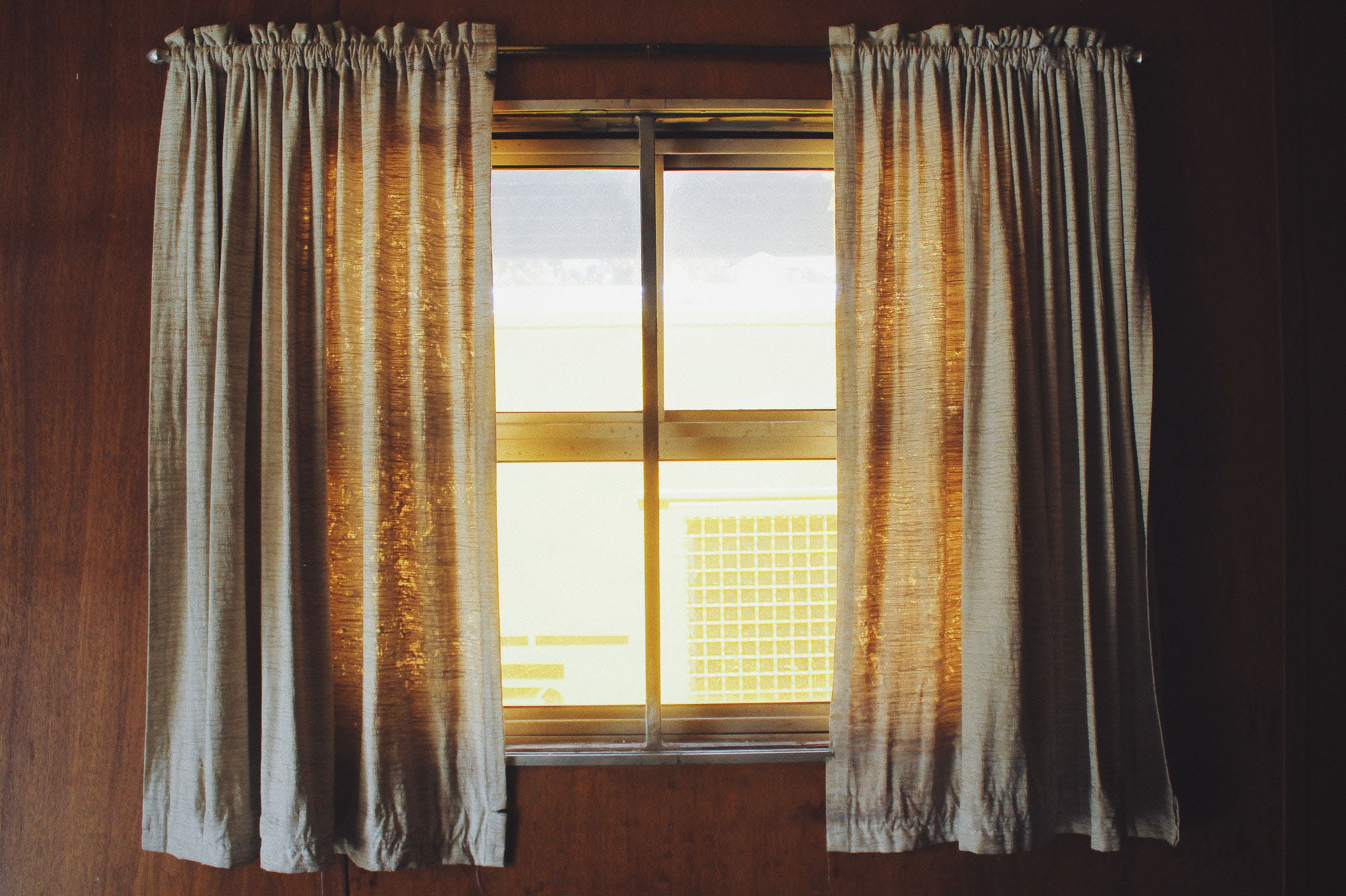 A window with white curtains with warm sunlight coming through