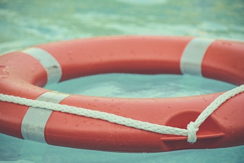 Red life preserver floating in a pool.