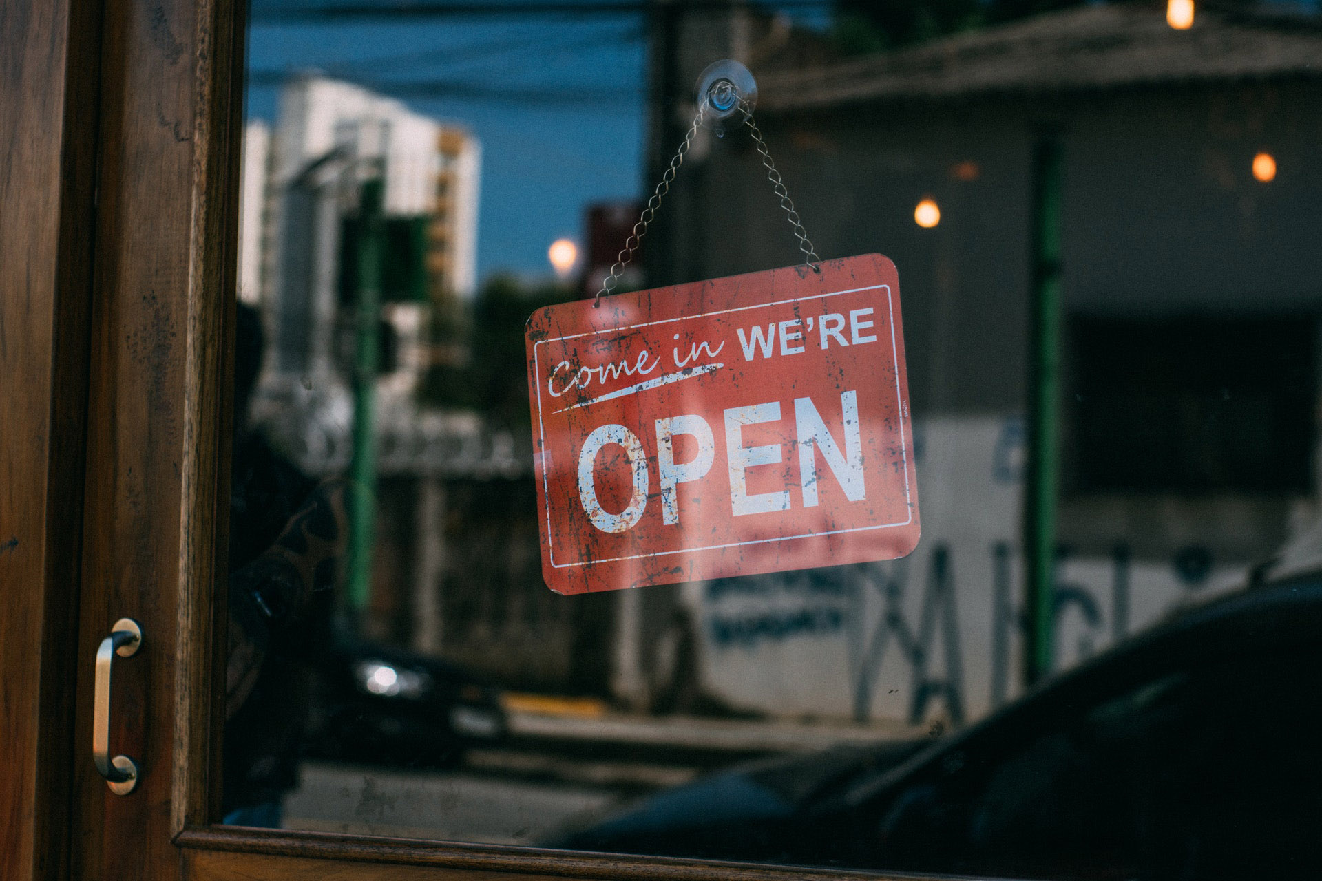 We are open sign in a shop's glass door