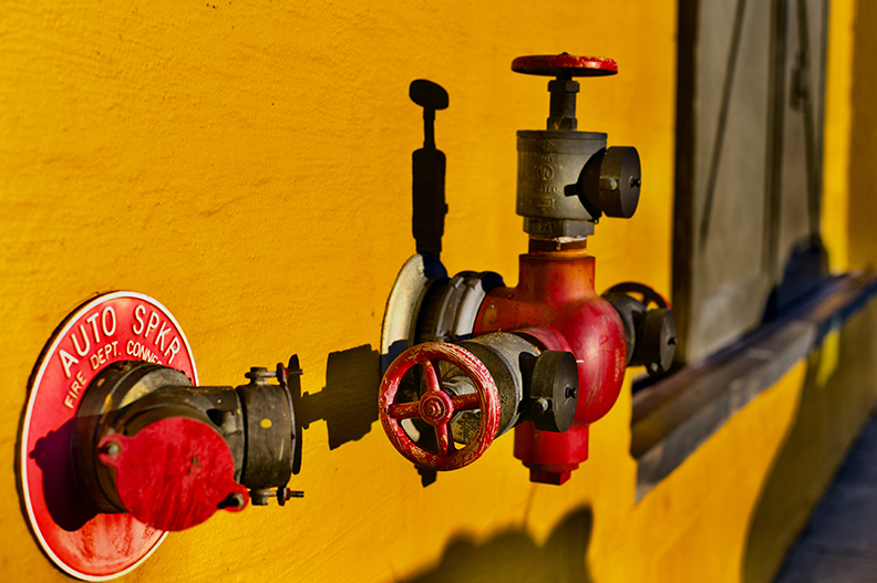 Part of fire sprinkler system mounted to the outside of a house wall