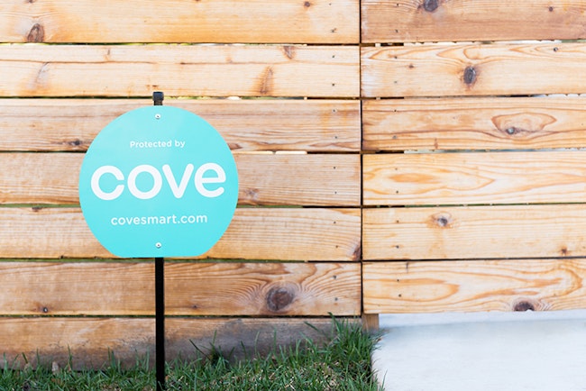 Cove Yard Sign In Front of Wooden Fence