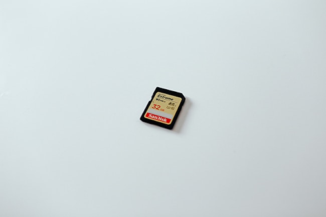 SD card on white surface. SD cards can be used to store motion detector camera footage.